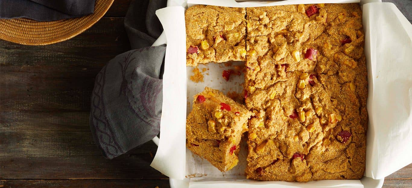 Vegan Cornbread in a white square dish with parchment paper underneath