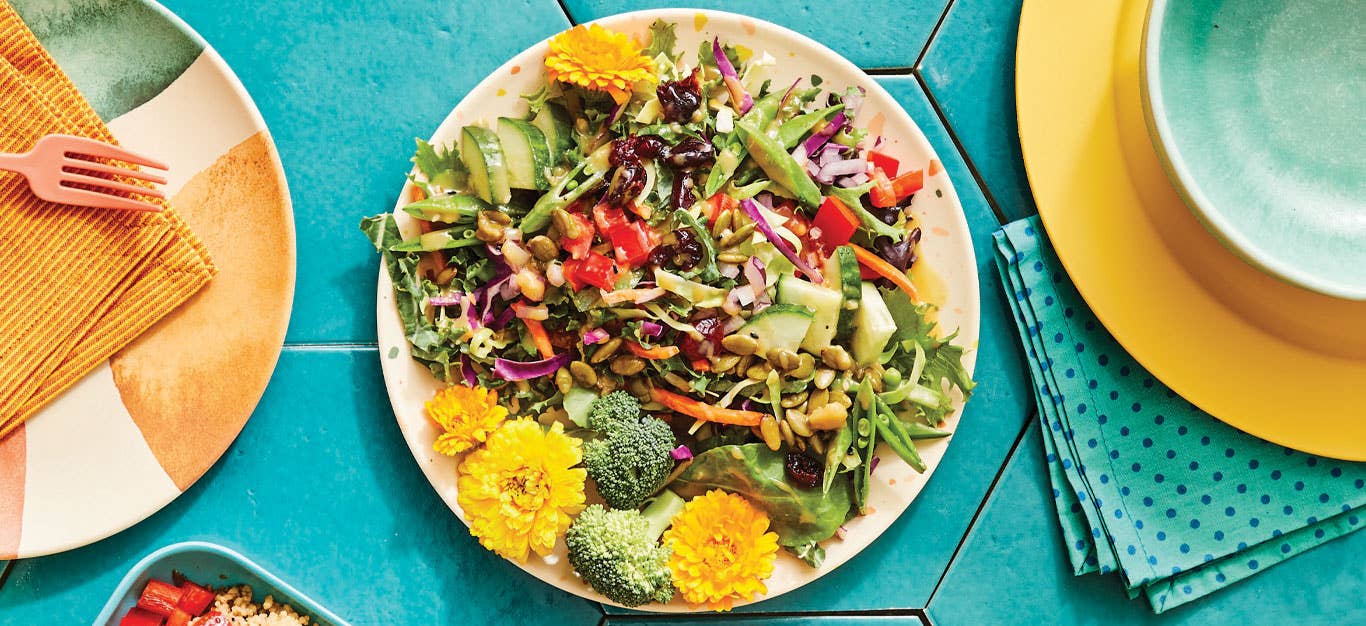 Kid-Friendly Edible Flower Salad on a whitte ceramic plate against teal tile background