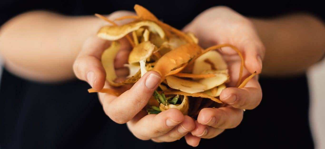 Cupped hands holding vegetable scraps