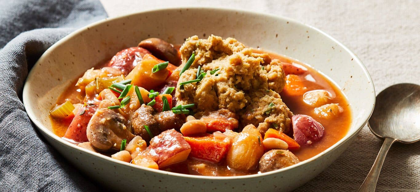 Vegetable Stew with Herbed Dumplings in a white ceramic bowl