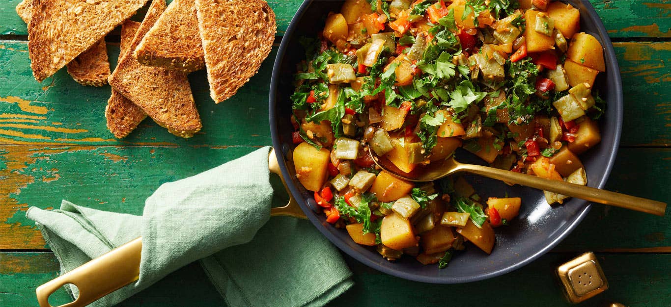 Nopales and Potatoes Breakfast Hash in a grey bowl against a green wooden tabletop