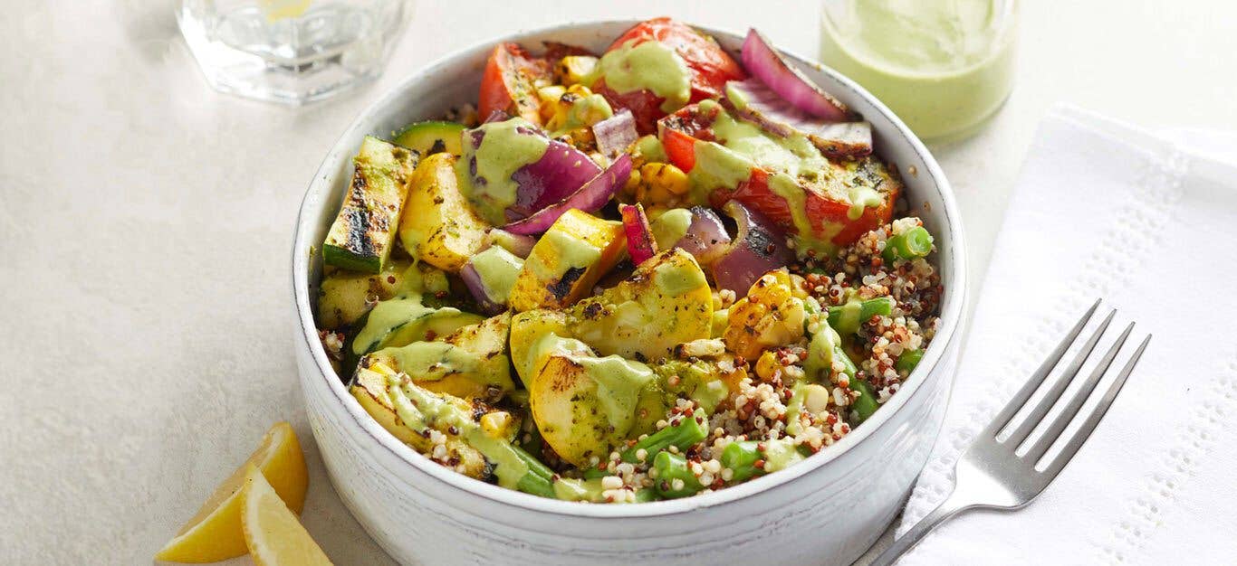 Pesto Grain Bowl with Grilled Vegetables in a white bowl with a metal fork