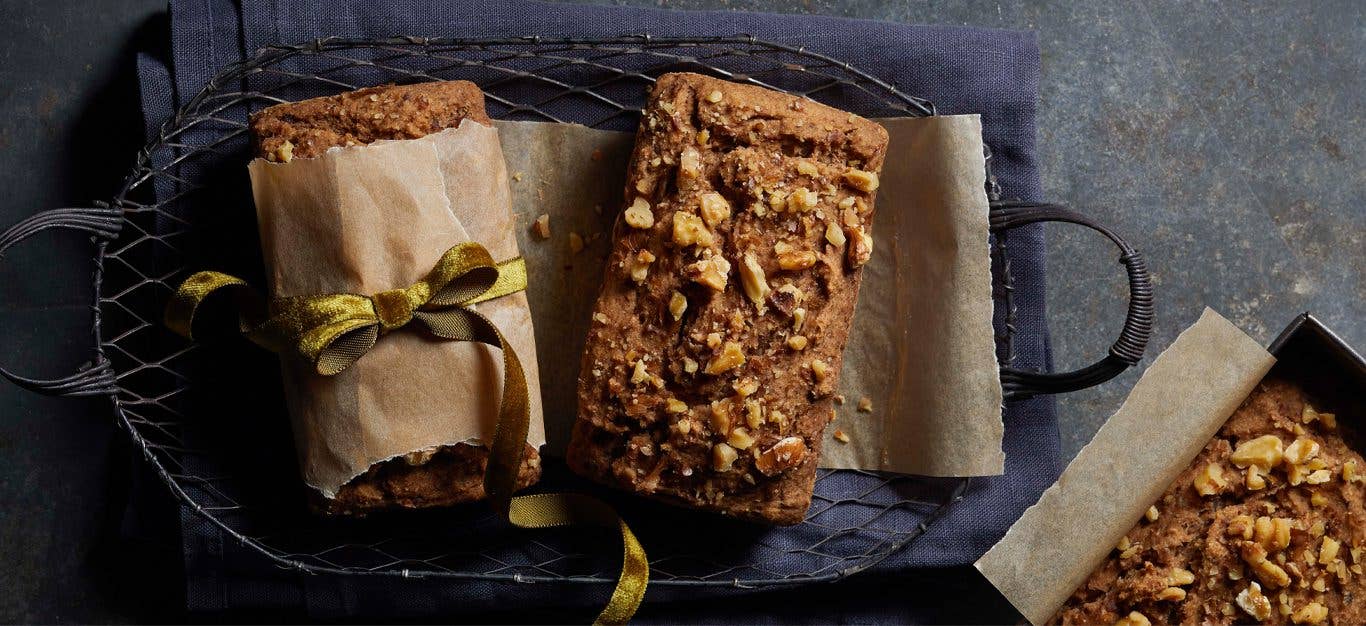 Spelt Banana-Walnut Bread mini loaves wrapped in parchment paper with a green ribbon bow